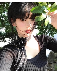 Gros plan d'un foulard en soie vintage à pois avec détail de fleur sur un mannequin