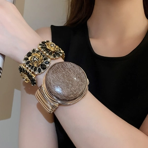 Detail of vintage flower bracelet with crystals and gold-wired wrap stone bangle