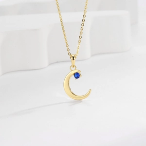 Minimalist gold crescent moon necklace with blue gemstone on thin chain for women