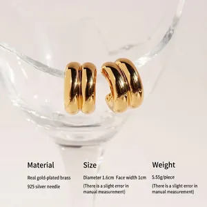 Minimalist double layer golden C-shaped hoop earrings on glass for a modern look