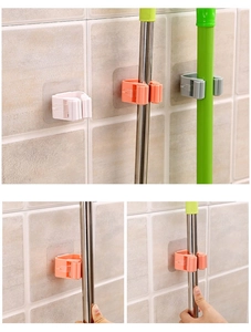 Detail of wall-mounted mop holder with non-slip grippers and adhesive backing on tiles