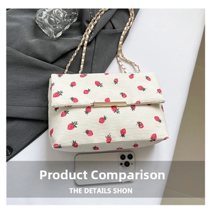 Detail of cream corduroy shoulder bag with red strawberry prints and gold chain strap