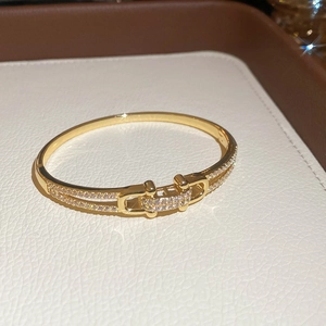 Vue détaillée du bracelet jonc doré avec fermoir géométrique et pavage en zircons brillants