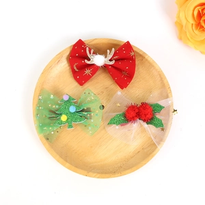 Detailed view of three festive Christmas hair clips with mesh bows, reindeer and tree motifs