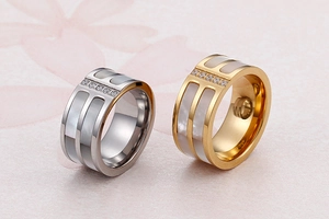 Close-up of wide ring with white mother-of-pearl inlay and zircons in gold and silver
