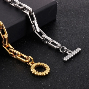 Détail de bracelet à gros maillons carrés avec fermoir OT en finitions or et argent