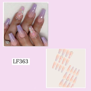 Detail of long ballerina nails with nude purple gradient, butterfly patterns, and rhinestones