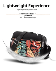 Detail of lightweight printed crossbody bag with multiple zippers and feather visual