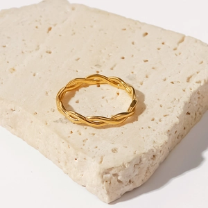 Macro shot of 18K gold plated stainless steel twisted rope ring on stone surface