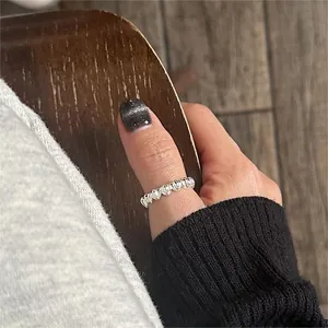 Close-up of textured 925 sterling silver heart ring worn on thumb with wavy pattern