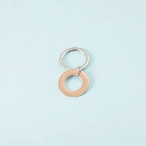 Close-up of polished silver and rose gold intertwined circular pendant on blue backdrop