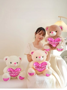 Detailed view of plush teddy bears in white, apricot, and brown holding shiny pink LOVE hearts