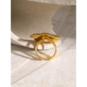 Detailed macro view of an 18k gold flower ring featuring a clear crystal center stone