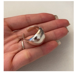 Macro shot of silver liquid metal texture open ring showing premium matte finish and detail