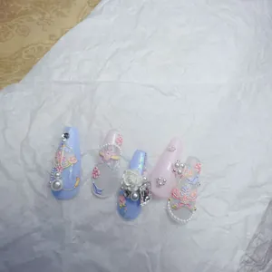 Detail of 3D embossed rose nail charms with pearls and floral patterns on blue nails