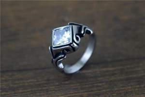 Macro shot of vintage stainless steel ring with square clear gemstone and engraved details