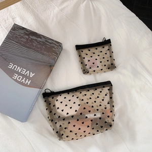 Two-piece black mesh makeup bag set with heart pattern on textured white background
