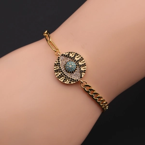 Detailed shot of gold plated evil eye bracelet with blue zirconia on model's wrist