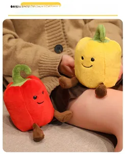 Close-up of cute red and yellow chili pepper plush toys with smiling faces on a sofa