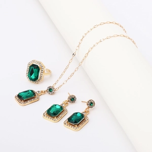 Macro shot of green gemstone jewelry set with gold metal and sparkling crystal borders