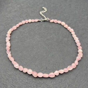 Detailed view of irregular pink rose quartz stone necklace with stainless steel clasp