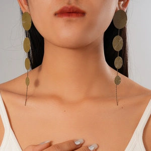 Close-up of model wearing tiered geometric circular fringe drop earrings in vintage gold