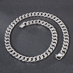 Close-up of polished silver stainless steel Cuban link necklace with lobster clasp detail