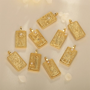 Detailed view of nine gold-plated tarot card pendants with white zircon inlays on fabric