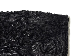 Makro-Detail des schwarzen Paillettenstoffs mit 3D-Rosenmuster und luxuriösem Finish