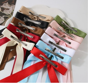 Detail of colorful double-layer cotton bow hair clips in a white ceramic dish