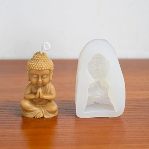Detail showing silicone Buddha mold and finished 3D scented candle on wooden table