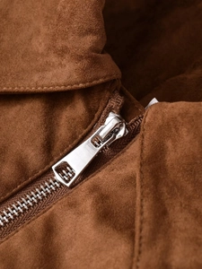 Detail of high-quality metal zipper and dark brown suede fabric on a cropped jacket