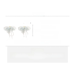 Détail de boucles d'oreilles nœuds en dentelle vert clair avec pampilles de perles