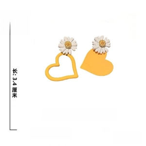 Detail of asymmetric yellow heart earrings with white daisies and 925 silver needles