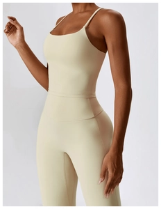 Detalle de los tirantes finos y el cuello en U de un body de yoga crema para mujer