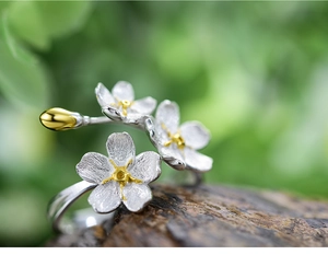 Macro detail of S925 sterling silver forget-me-not flower ring with gold-plated accents