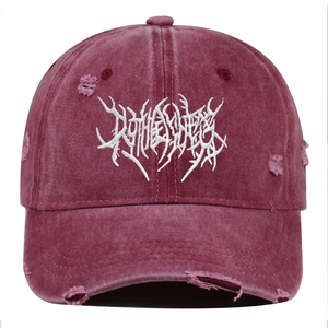 Detail of distressed burgundy baseball cap featuring white gothic letter embroidery