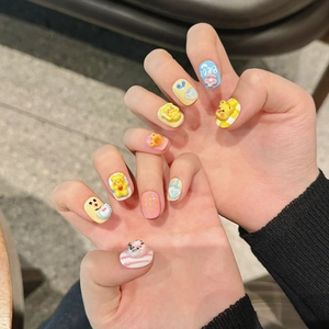Detail of 3D bear press-on nails with yellow bear, pink flowers and blue heart patterns