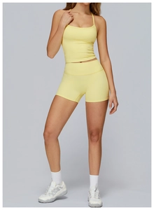 Dettaglio dei pantaloncini da yoga gialli a vita alta e crop top slim fit coordinato