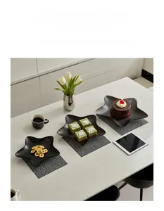 Close-up of black star-shaped iron tray with matte finish on marble surface
