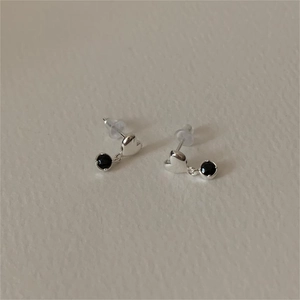Minimalist 925 silver heart stud earrings with black zircon stones on ivory background