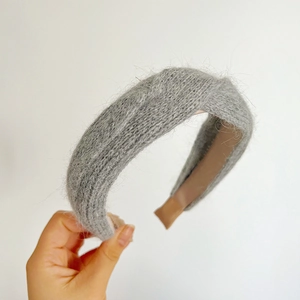 Detail view of a gray plush knitted headband with brown anti-slip lining for winter fashion