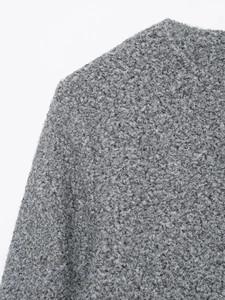 Detailed macro view of gray textured bouclé wool fabric on jacket shoulder and collar
