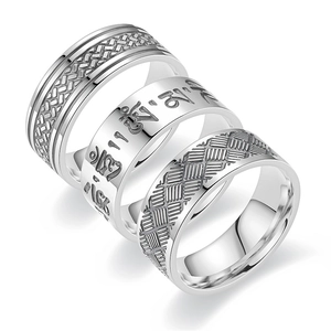 Detailed view of three silver titanium steel rings with textured weave and mantra patterns