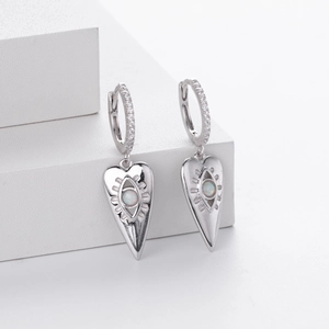 Detail of silver heart earrings with opal evil eye inlay and pavé zircon stones