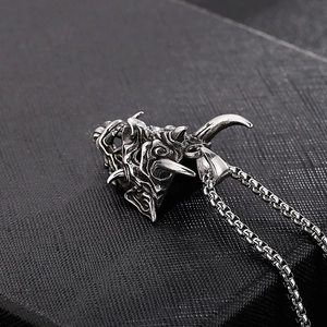 Macro detail of gothic horned monster head pendant in silver-tone stainless steel