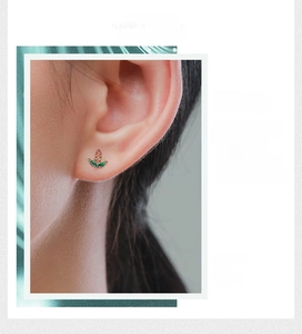 Close-up of s925 silver corn stud earrings with orange and green gemstones on model