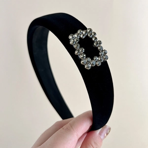 Macro detail of black velvet headband with sparkling rhinestone rectangle buckle