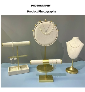 Détail d'un ensemble de présentoirs à bijoux en métal doré avec buste et supports beiges