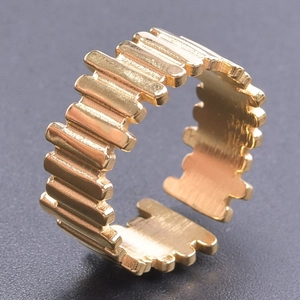 Makroaufnahme eines goldenen Titanrings mit vertikalen Rillen und verstellbarem Design